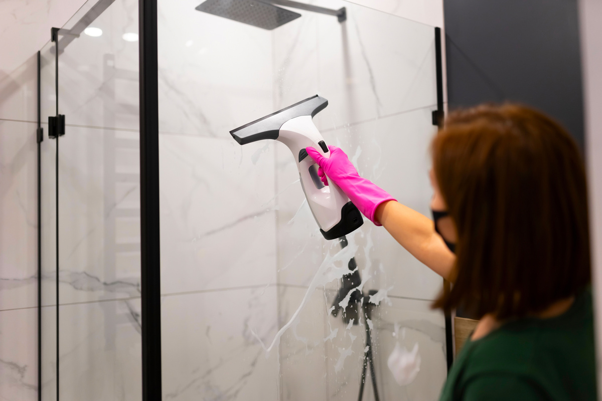 Person Cleaning Shower Glass 